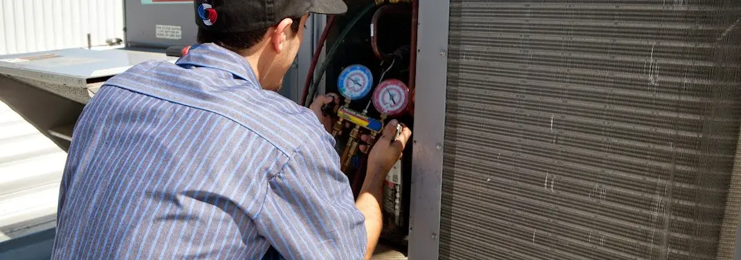 HVAC technician servicing a condenser unit in Luling